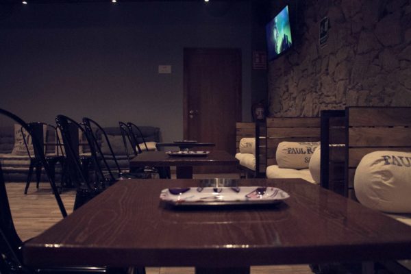 barcelona coffeeshop bar and tables with chairs and screens on the wall